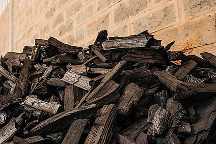 Pile of charcoal pieces against a warehouse wall